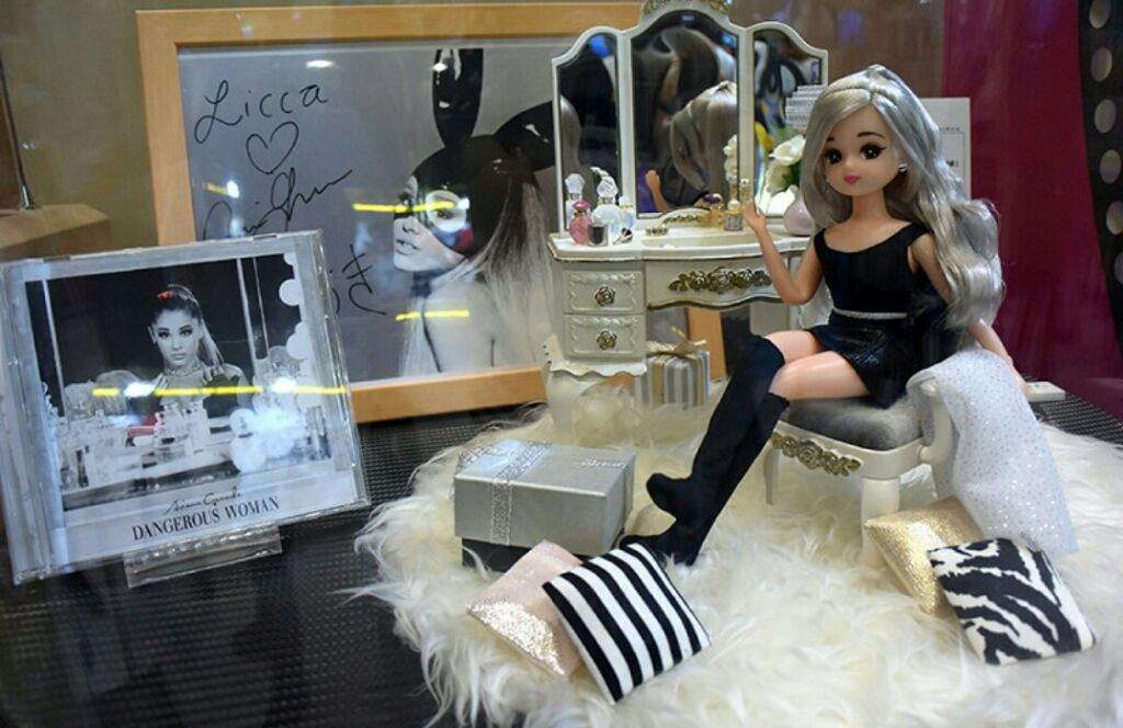 Fashion doll displayed beside music and style memorabilia.